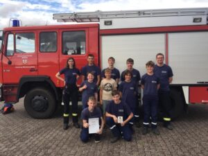 Jugendgruppe vor einem Feuerwehrfahrzeug zum Siegerfoto